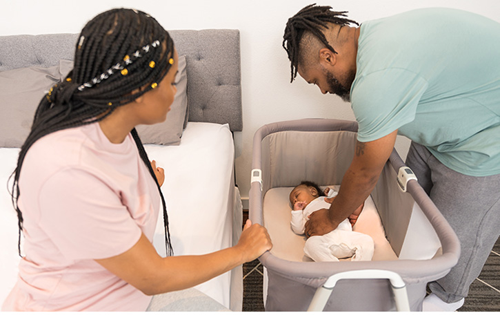 A man is preparing to lift a baby as a woman watches on.